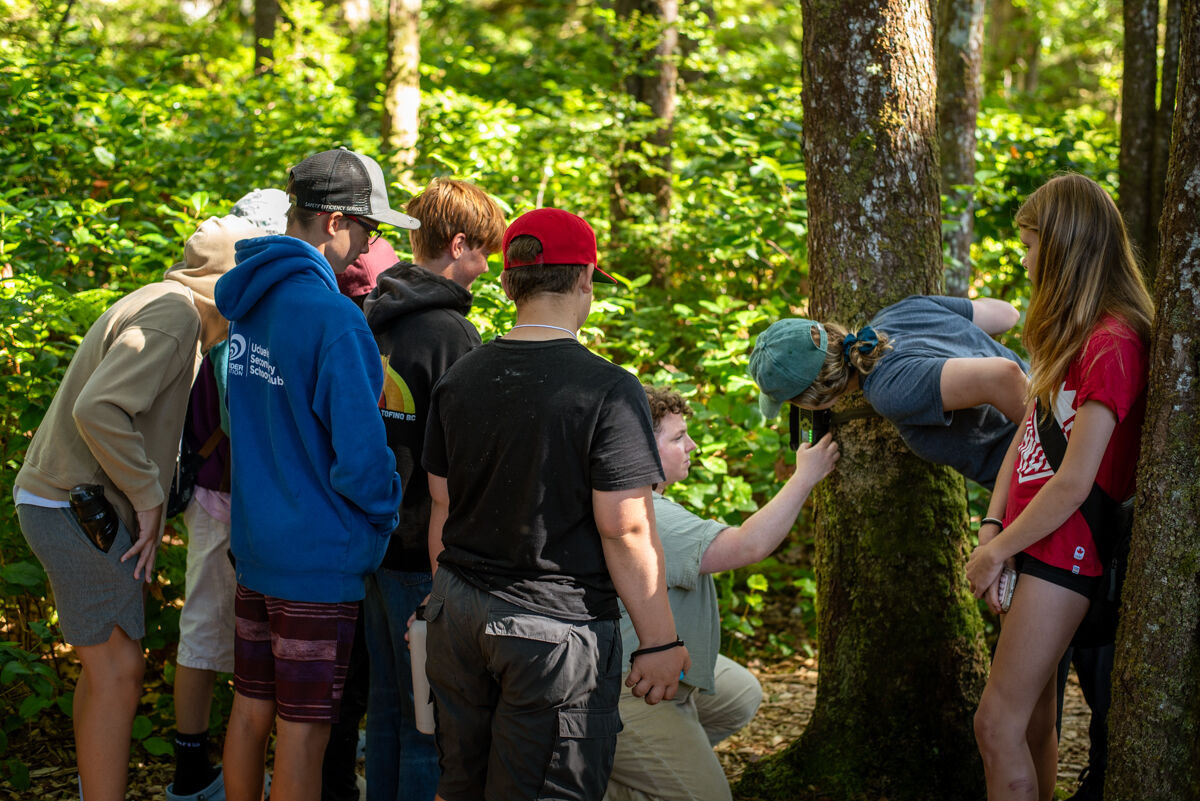 youth crowded around videographer Sam Rose Philips, learning about trail cams